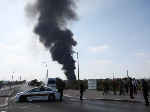 emergency personnel work as smoke rises following a missile attack from iran in herzliya israel june 17 2025 reuters ronen zvulun