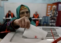 a woman putting her ballot inside a ballot box photo anadolu agency