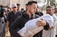a palestinian man holding the body of a child wrapped in a white sheet photo anadolu agency