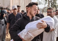 a palestinian man holding the body of a child wrapped in a white sheet photo anadolu agency