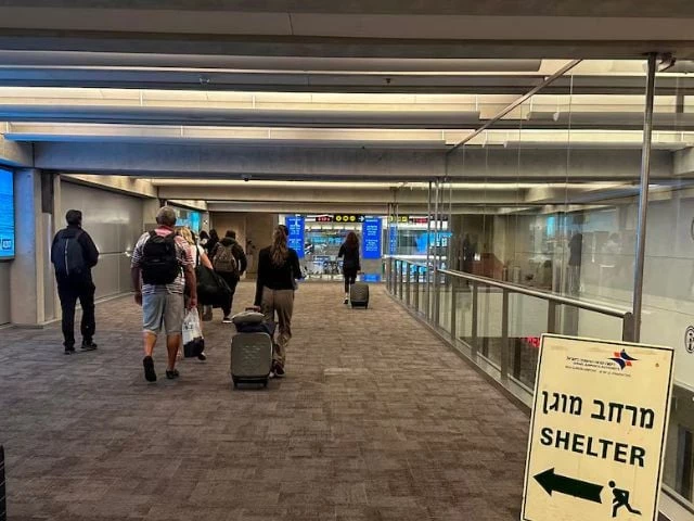 people walk next to a sign directing for shelter after landing in israel at the arrivals section of ben gurion international airport in lod near tel aviv israel october 11 2023 photo reuters people walk next to a sign directing for shelter after landing in israel at the arrivals section of ben gurion international airport in lod near tel aviv israel october 11 2023 photo reuters