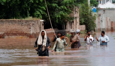 residents wade through a flooded road following monsoon rains and rising water levels in qadirabad village near the chenab river in punjab province pakistan august 28 2025 photo reuters
