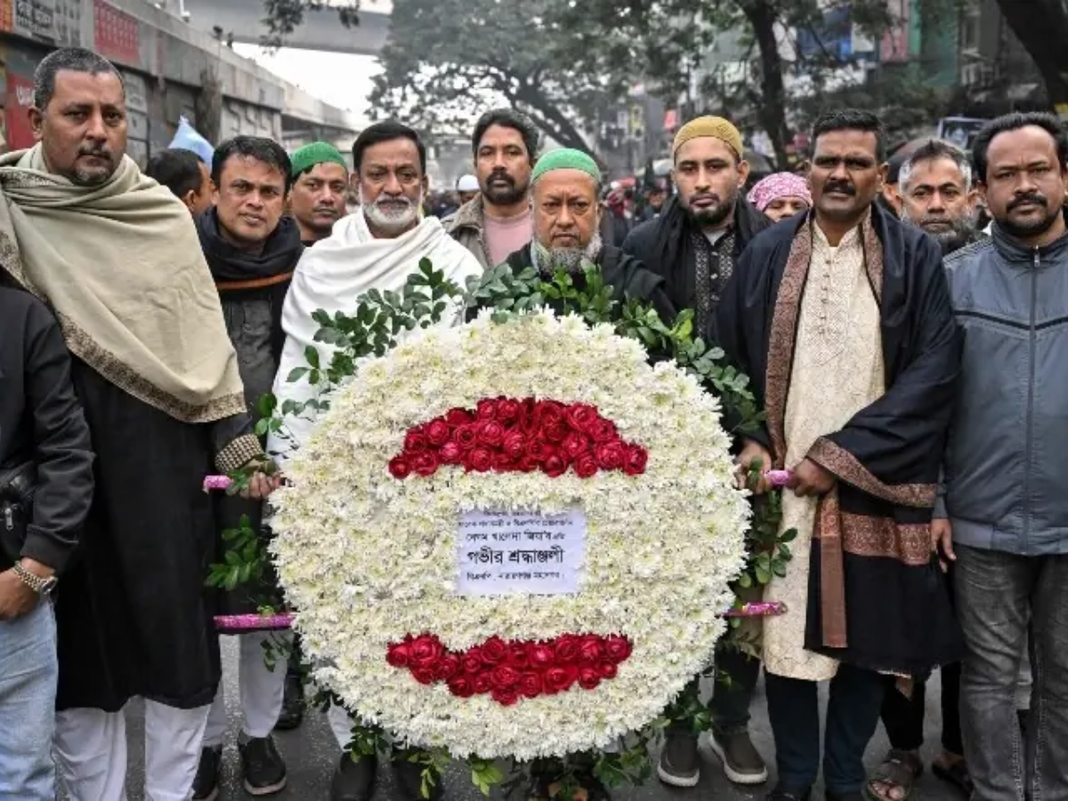 Supporters of Bangladesh’s former prime minister Khaleda Zia carry a wreath to mourn her death as they gather before the funeral ceremony in Dhaka on December 31, 2025 Photo: AFP