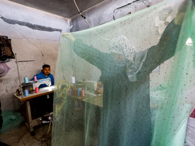 Photo: A Palestinian woman works at a sewing shop producing and repairing wedding dresses/Reuters