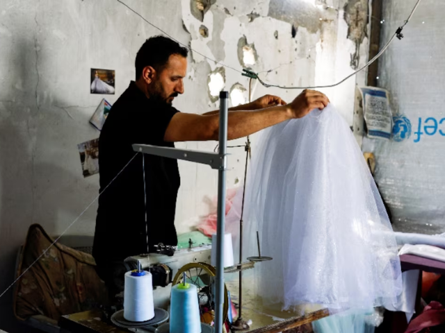 Photo: A Palestinian tailor repairs and recycles wedding dresses and children’s gowns/Reuters