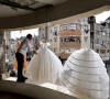 photo palestinian man hangs wedding dresses at a shop with damaged walls and ceiling reuters