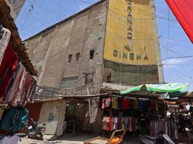 photo street vendors gather outside the faded facade of the granada cinema central baghdad afp photo street vendors gather outside the faded facade of the granada cinema central baghdad afp