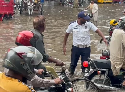 a traffic police officer redirects traffic as heavy monsoon rains lash lahore for the second day photo express a traffic police officer redirects traffic as heavy monsoon rains lash lahore for the second day photo express