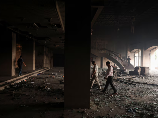 Members of the media walk inside the Parliament house which was set on fire by protesters, following Monday's killing of 19 people after anti-corruption protests that were triggered by a social media ban, which was later lifted, in Kathmandu, Nepal, September 10, 2025. Photo: Reuters