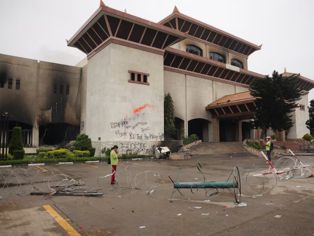 Members of the media stand in front of the Parliament house which was set on fire by protesters, following Monday's killing of 19 people after anti-corruption protests that were triggered by a social media ban, which was later lifted, in Kathmandu, Nepal, September 10, 2025. Photo: Reuters