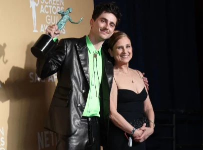timoth e chalamet twins with his mother in head to toe orange at marty supreme nyc premiere