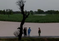 residents stand on a higher ground with the flooded field in the background following monsoon rains and rising water levels of the chenab river in patraki village chiniot district punjab province pakistan august 30 2025 photo reuters