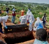 red cross workers wearing personal protective equipment ppe prepare to lower the coffin of dr tibenderana katho blaise who worked at the centre medical evangelique cme in hoho commune and died of ebola virus as aid agencies intensify efforts to contain a new ebola outbreak caused by the bundibugyo virus at the nyamurongo cemetery in bunia town ituri province democratic republic of congo may 26 2026 photo reuters