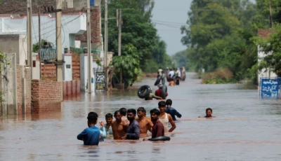 residents wade through a flooded road following monsoon rains and rising water levels in qadirabad village near the chenab river in punjab province pakistan august 28 2025 photo reuters