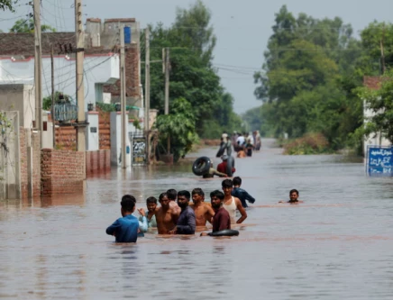 residents wade through a flooded road following monsoon rains and rising water levels in qadirabad village near the chenab river in punjab province pakistan august 28 2025 photo reuters