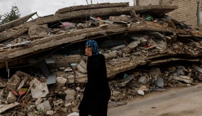 a resident walks while covering her nose to protect against the smell rising from a building containing homes and a restaurant hit by an israeli strike hours before the ceasefire amid a 10 day ceasefire between lebanon and israel in zrarieh lebanon april 19 2026 photo reuters