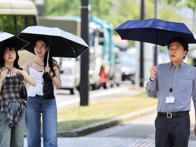 People use parasols to cope with the heatwave, in Hiroshima, Japan, August 5, 2025. Photo: Reuters