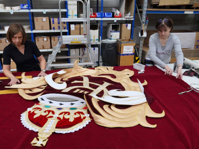 Seamstresses work on one of two parts of the new London Royal Opera House stage curtains/ REUTERS