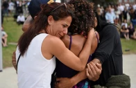 people embrace as they visit a makeshift memorial following the attack on a jewish holiday celebration at sydney s bondi beach in sydney australia december 15 2025 photo reuters