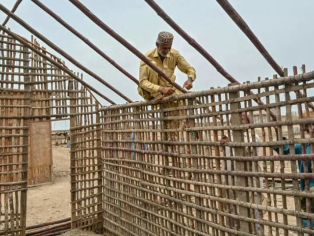 Haji Karam Jat, whose house was swallowed by the rising water level, rebuilt his new hom farther inland  Asif HASSAN / AFP