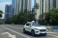 a driverless car by apollo go baidu s robotaxi service drives past another apollo go robotaxi parked on the side of a road in wuhan hubei province china july 19 2024 photo reuters