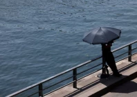 a person shelters from the sun under an umbrella along the banks of the river seine in paris as temperatures rise during a heatwave affecting a large part of france june 22 2026 photo reuters