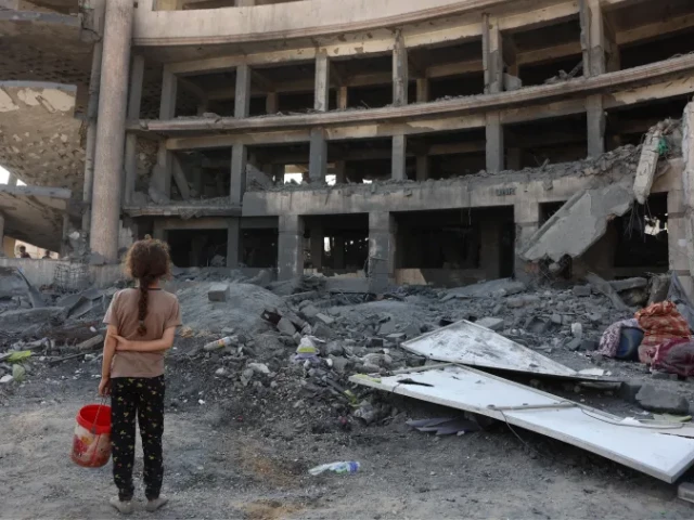 a palestinian girl surveys the destruction after a strike on the sheikh radwan health centre in the north of gaza city photo afp