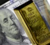 a photo of a gold bar with a us dollar behind it photo anadolu agency a photo of a gold bar with a us dollar behind it photo anadolu agency