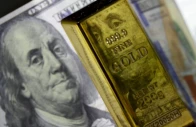 a photo of a gold bar with a us dollar behind it photo anadolu agency a photo of a gold bar with a us dollar behind it photo anadolu agency