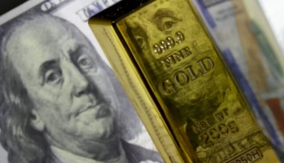 a photo of a gold bar with a us dollar behind it photo anadolu agency