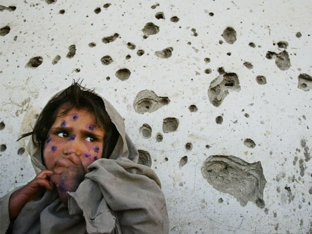 mohboba 7 stands near a bullet ridden wall in kabul as she waits to be seen at a health clinic in march 2002 photo afp