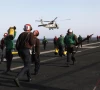 flight deck personnel run to receive a helicopter preparing to land on the flight deck on board the nimitz class aircraft carrier uss abraham lincoln cvn 72 as it patrols the arabian gulf during a strait of hormuz transit february 14 2012 photo reuters
