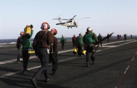 flight deck personnel run to receive a helicopter preparing to land on the flight deck on board the nimitz class aircraft carrier uss abraham lincoln cvn 72 as it patrols the arabian gulf during a strait of hormuz transit february 14 2012 photo reuters