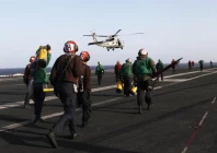 flight deck personnel run to receive a helicopter preparing to land on the flight deck on board the nimitz class aircraft carrier uss abraham lincoln cvn 72 as it patrols the arabian gulf during a strait of hormuz transit february 14 2012 photo reuters