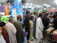 people stand in line to buy essential food items on subsidised rates at an outlet of the state run utility stores corporation in dha karachi on friday photo jalal qureshi express