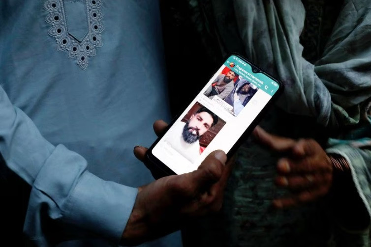 a family member shows a mobile phone with a picture of muhammad nadeem 38 father of three sons who along with others died when a migrant boat shipwrecked off the coast near benghazi in libya outside his family home in hariyawala town in gujrat district of punjab province pakistan march 3 2023 reuters akhtar soomro