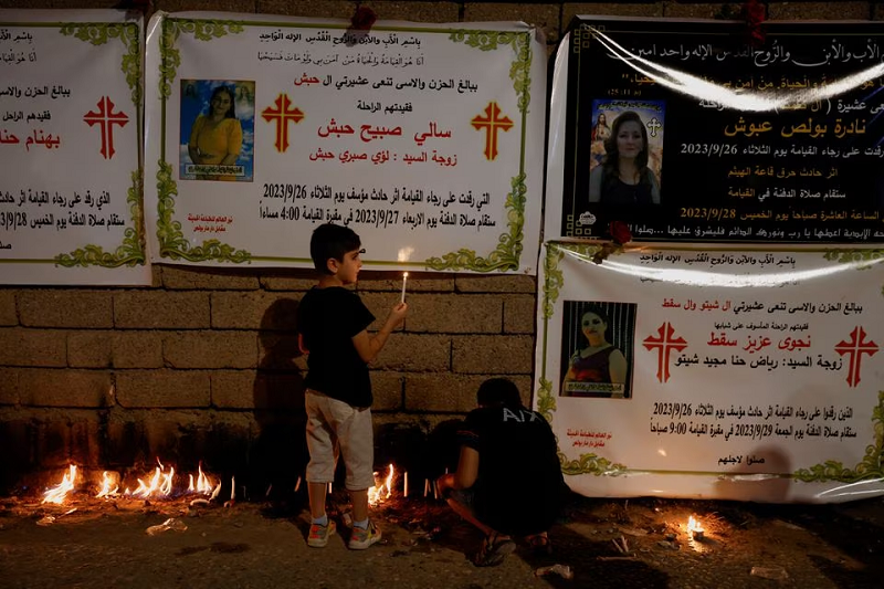 christians light candles near pictures of victims of a fatal fire at a wedding celebration in hamdaniya iraq september 29 2023 photo reuters