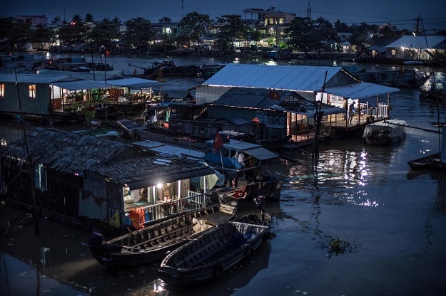 A man living on a boat in a canal off the Song Hau river at the floating Cai Rang market looks out from the porch of his home in Can Tho, a small city in the Mekong Delta. PHOTO: AFP