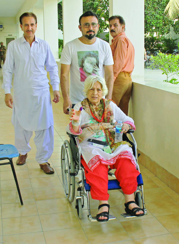 Voter shows ink mark on wheel chair Defence Karachi By-Election Oct 21, 2018 Athar Khan