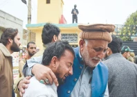 an elderly man tries to comfort his younger companion shattered by the death of loved ones in a suicide attack at an imambargah in islamabad photo reuters