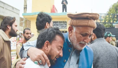an elderly man tries to comfort his younger companion shattered by the death of loved ones in a suicide attack at an imambargah in islamabad photo reuters