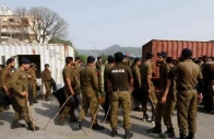 police officers guard a street where shipping containers have been used to block the road leading towards the red zone and parliament building in islamabad on april 3 2022 photo reuters