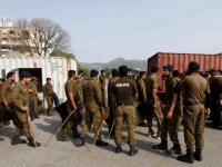 police officers guard a street where shipping containers have been used to block the road leading towards the red zone and parliament building in islamabad on april 3 2022 photo reuters