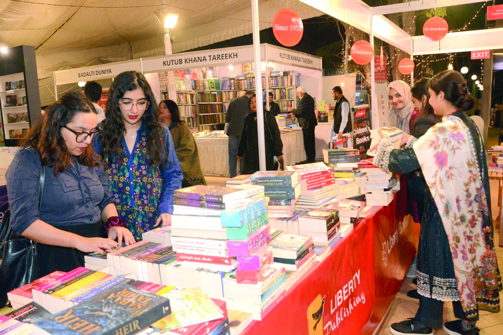 young women fuelled by an insatiable love for literature gather at the book stalls on klf day iii with eyes full of curiosity they sift through the pages of countless books to discover what resonates with their hearts and imaginations photo jalal qureshi express