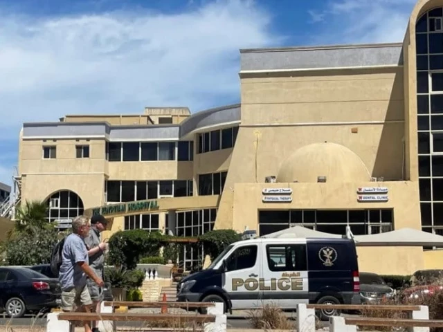 people walk next to a police vehicle in front of the hospital where the bodies of those who died when a tourist submarine sank off egypt s red sea resort city of hurghada are kept in hurghada egypt on march 27 2025 photo reuters