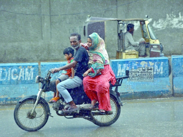 a woman leans on her husband as they ride through light rain in the city on friday photo jalal qureshi express a woman leans on her husband as they ride through light rain in the city on friday photo jalal qureshi express