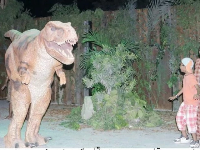 a young visitor stands in awe near a towering dinosaur installation as the time travel theatre is inaugurated offering families an immersive journey into prehistoric times through interactive and educational experiences photo inp