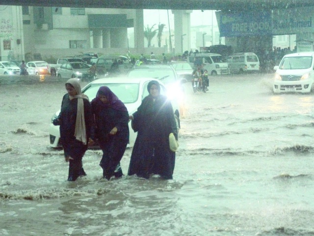 women workers wade through knee deep water after a long day struggling to reach home in the absence of public transport photo express