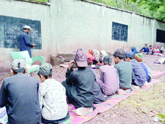 students at the government primary school kanshian bala in balakot continue their lessons seated on the ground highlighting the urgent need for proper classroom facilities two decades after the 2005 earthquake photo express