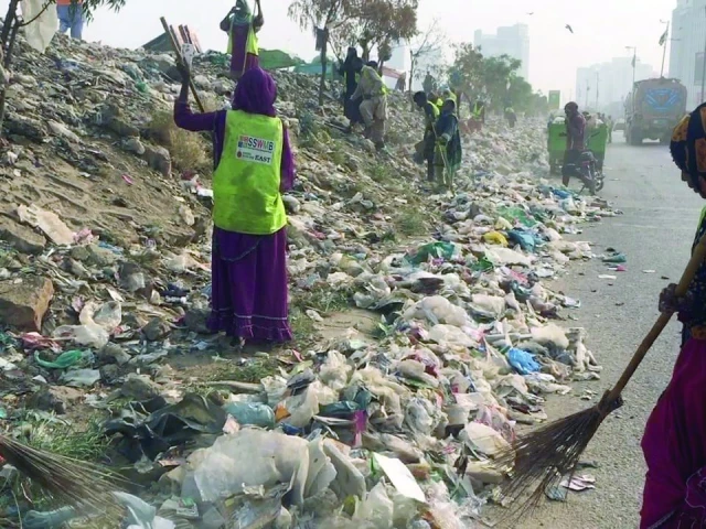 dozens of sindh solid waste management board workers and vehicles descend on the korangi expressway to clean the trash on friday after publication of news about piles of garbage in the express photo express